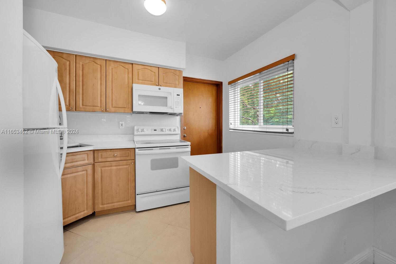 5630 Southwest 76th Street, Unit 3 Miami, FL 33143 - Photo 10 of 16 a kitchen with white cabinets and white appliances