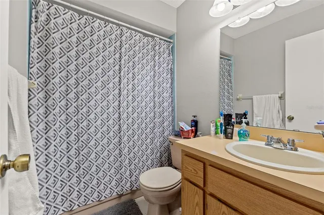 a bathroom with a granite countertop toilet and a sink