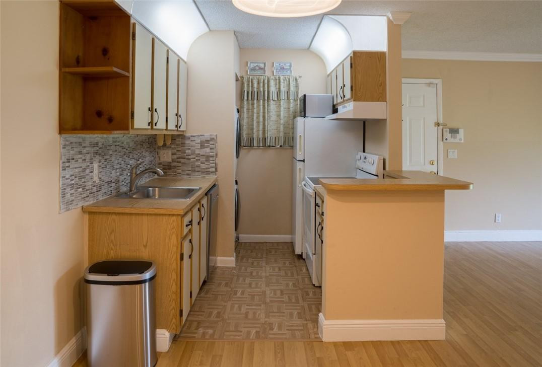 523 Trace Circle, Unit 106 Deerfield Beach, FL 33441 - Photo 13 of 26 a view of a kitchen with a sink and a refrigerator