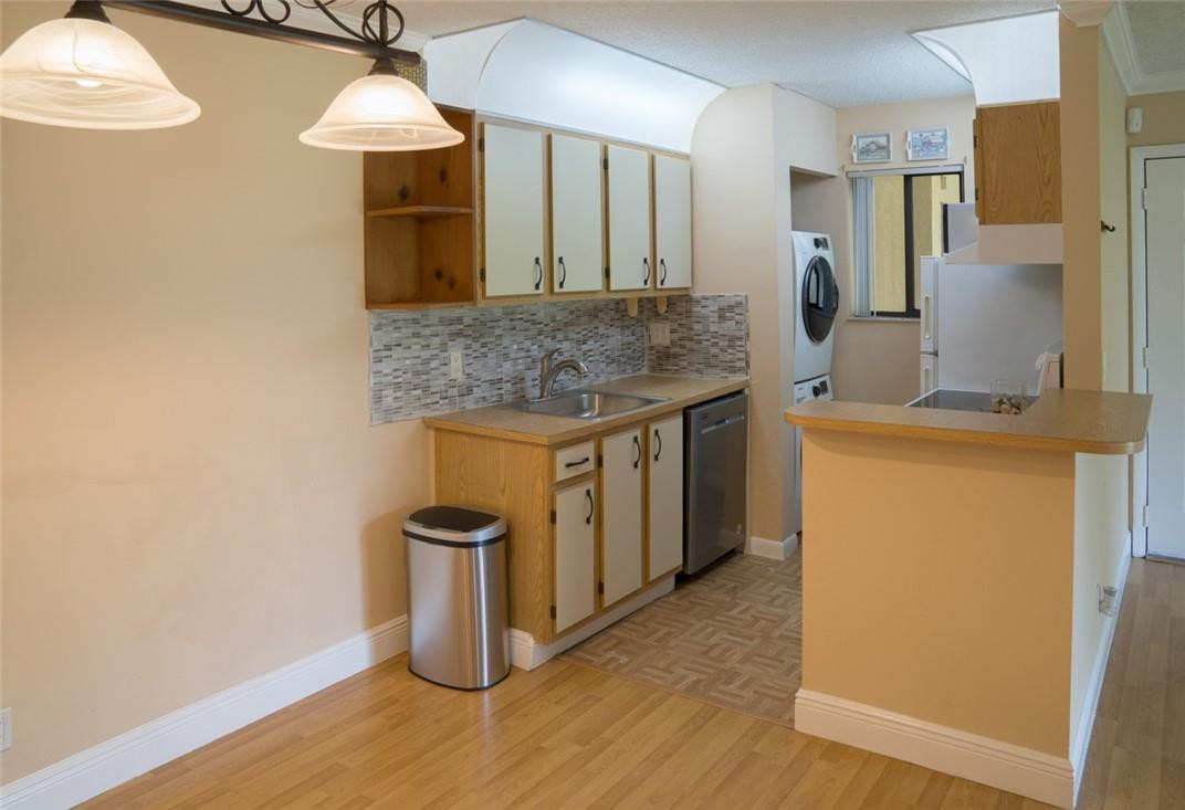 523 Trace Circle, Unit 106 Deerfield Beach, FL 33441 - Photo 15 of 26 a kitchen with a sink and a stove top oven