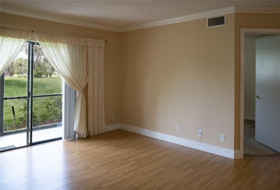 523 Trace Circle, Unit 106 Deerfield Beach, FL 33441 - Photo 6 of 26 a view of an empty room with wooden floor and a window