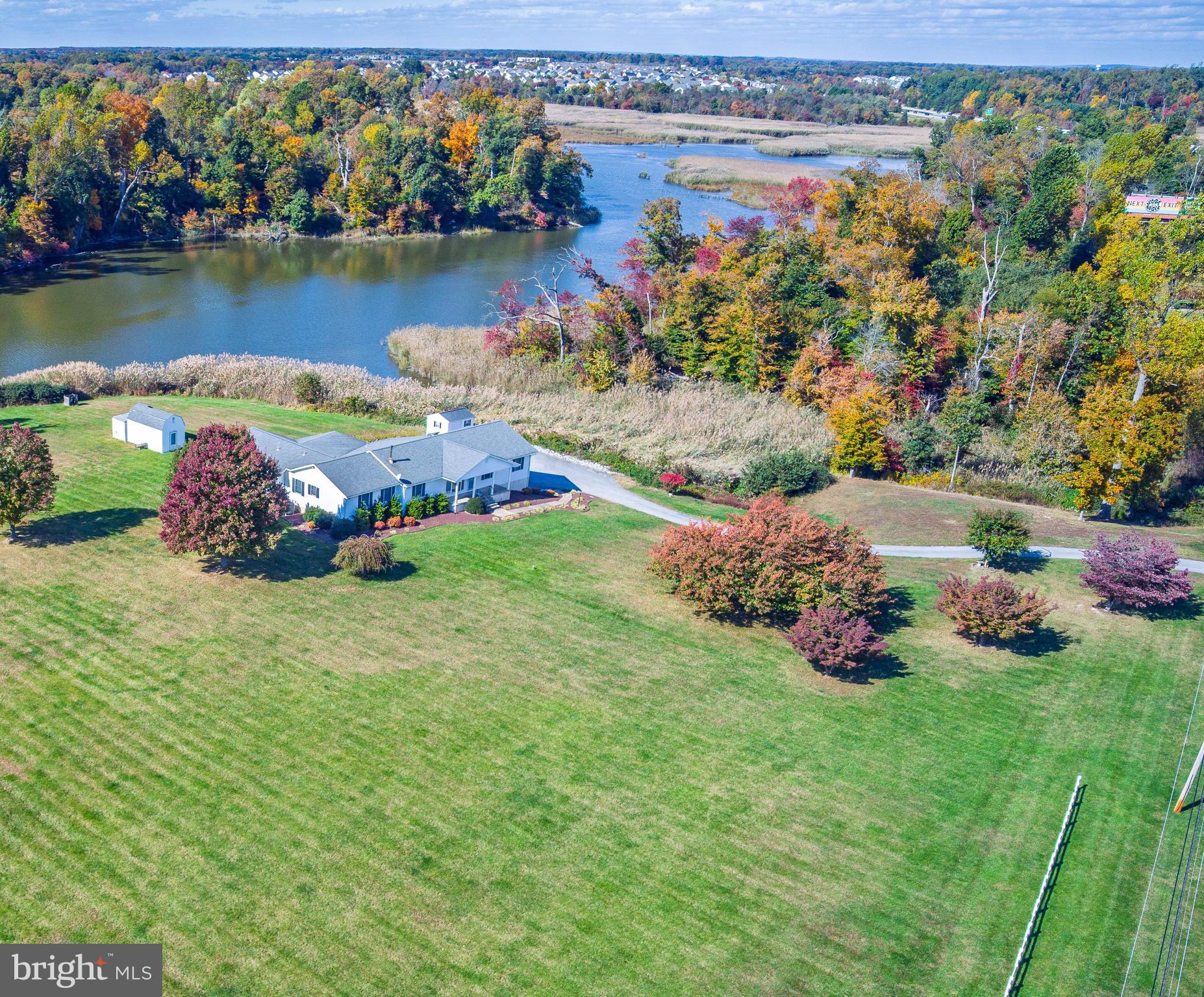 3349 Harris Road Townsend, DE 19734 - Photo 4 of 31 a view of a lake with lawn chairs and large trees