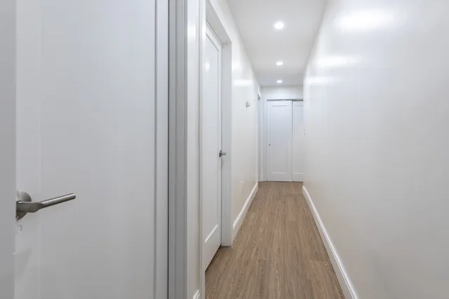 a view of a hallway with wooden floor