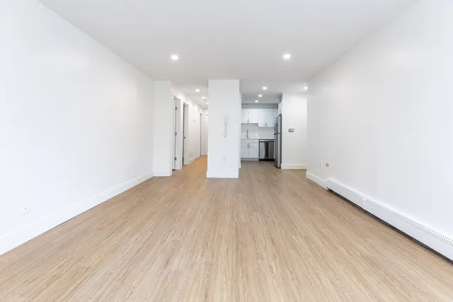 a view of a big room with wooden floor and windows