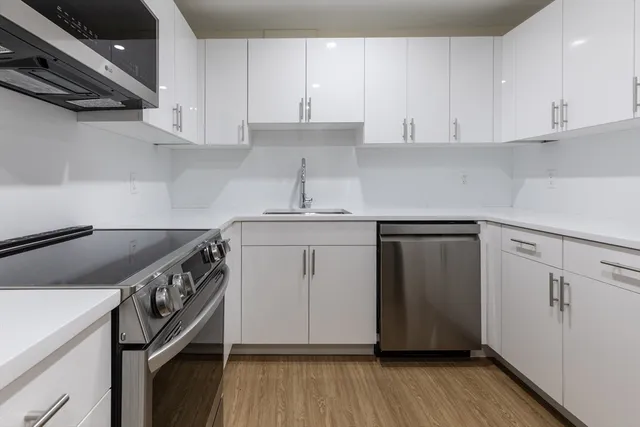 a kitchen with a sink a stove and cabinets