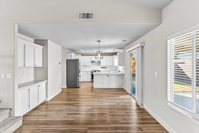 a large kitchen with kitchen island white cabinets and stainless steel appliances