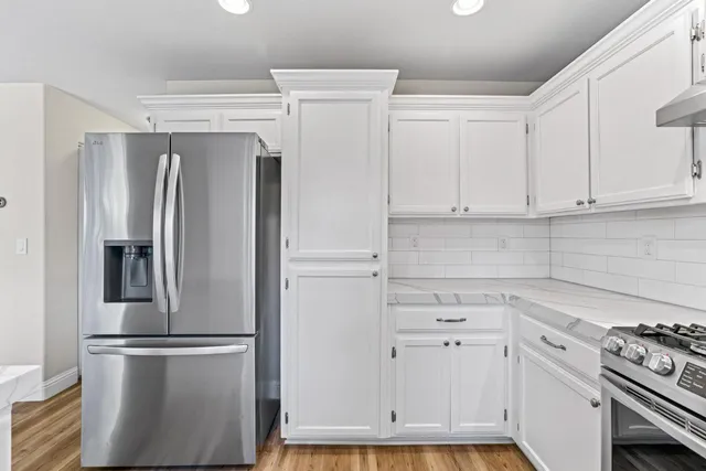 a kitchen with stainless steel appliances white cabinets and a refrigerator