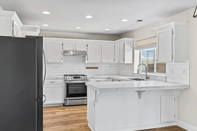 a kitchen with stainless steel appliances granite countertop a stove a sink and a refrigerator