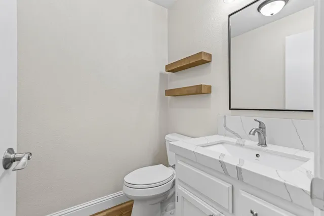 a bathroom with a sink a toilet and mirror