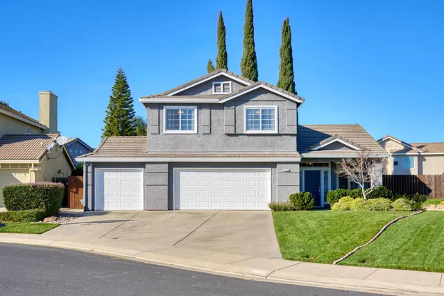 a front view of a house with a yard and garage