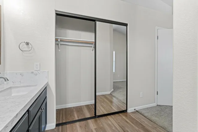 a bathroom with a granite countertop sink a mirror and a shower