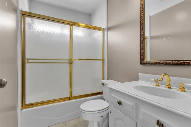 a bathroom with a granite countertop sink toilet and a mirror