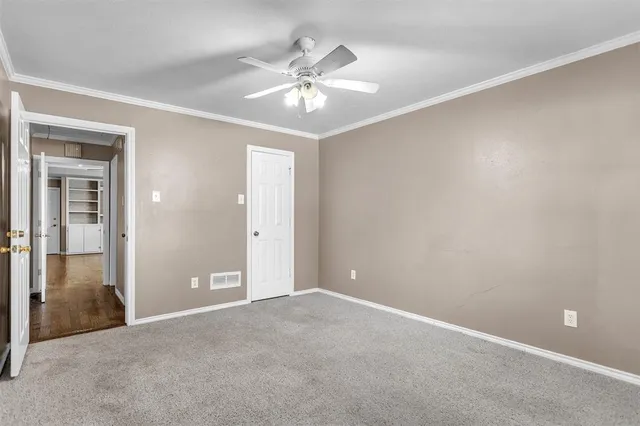 an empty room with fan and entryway