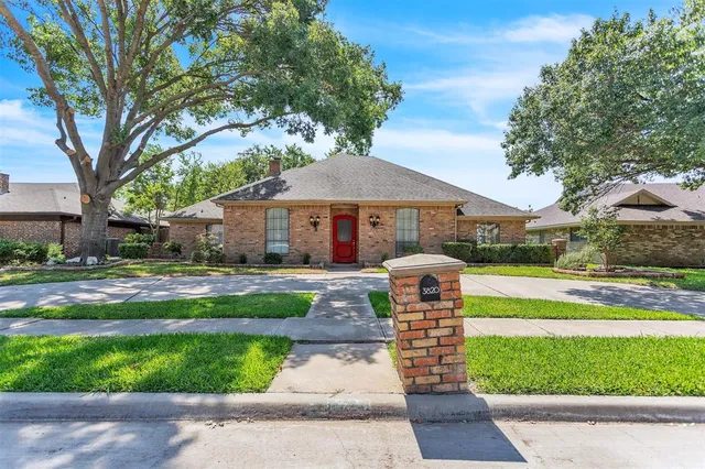 a front view of a house with fountain and garden