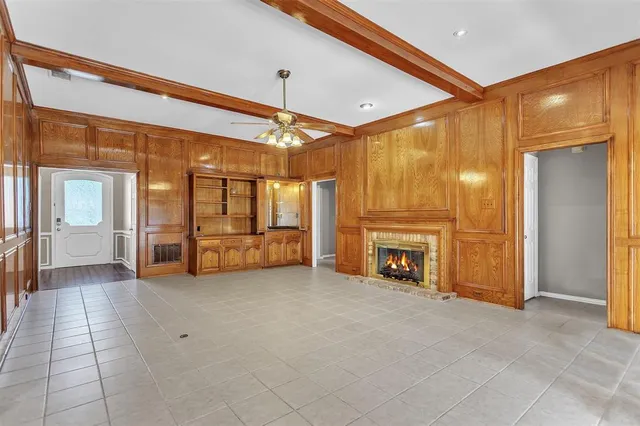 a view of an empty room with fireplace and windows