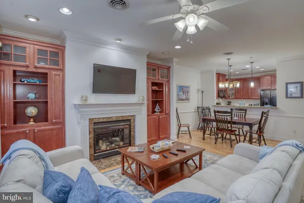 a living room with furniture a flat screen tv and kitchen view