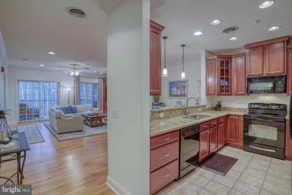 a large kitchen with stainless steel appliances kitchen island granite countertop a sink and cabinets