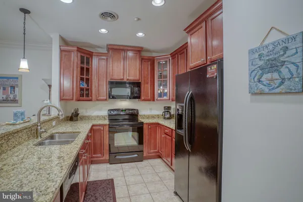 a kitchen with stainless steel appliances granite countertop a refrigerator stove top oven and sink