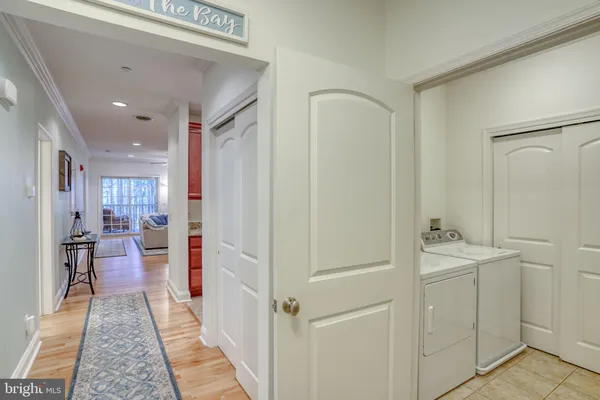 a hallway with white cabinets and wooden floor