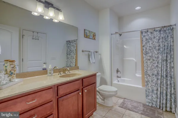 a bathroom with a granite countertop sink toilet mirror and shower