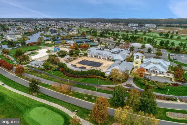 an aerial view of residential houses with outdoor space and trees