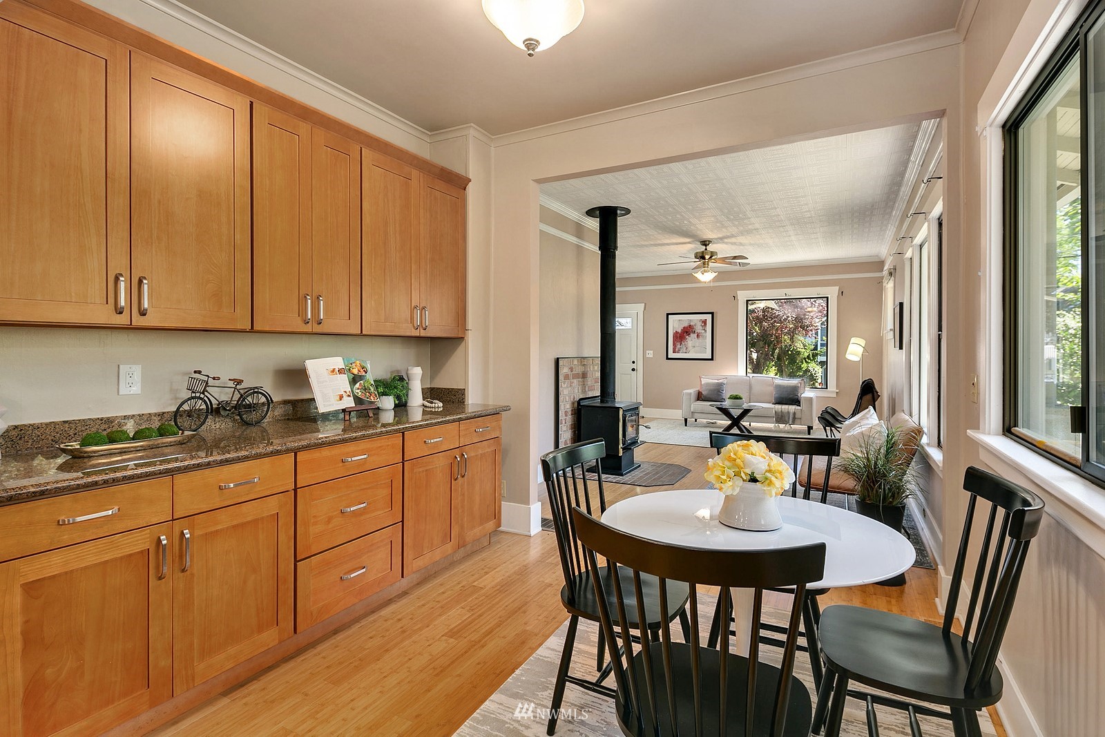 738 North 87th Street Seattle, WA 98103 - Photo 11 of 16 a kitchen with granite countertop a sink white cabinets dining table and chairs