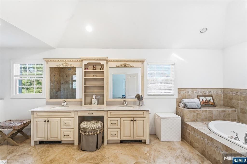 27 Pine Hill Road Old Tappan, NJ 07675 - Photo 35 of 50 a bathroom with a double vanity sink a large mirror and a bathtub