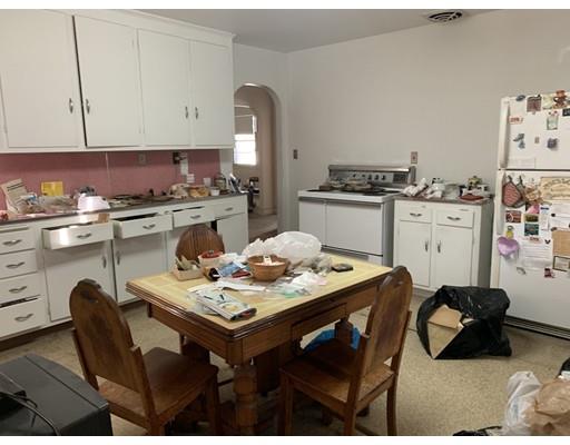 4 Baker Road Everett, MA 02149 - Photo 6 of 11 a kitchen with a table chairs stove and cabinets