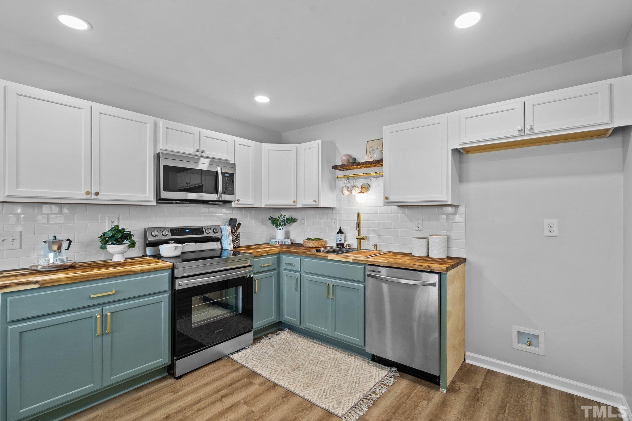 1013 Mockingbird Drive Raleigh, NC 27615 - Photo 11 of 41 a kitchen with stainless steel appliances granite countertop a sink a stove a refrigerator and cabinets