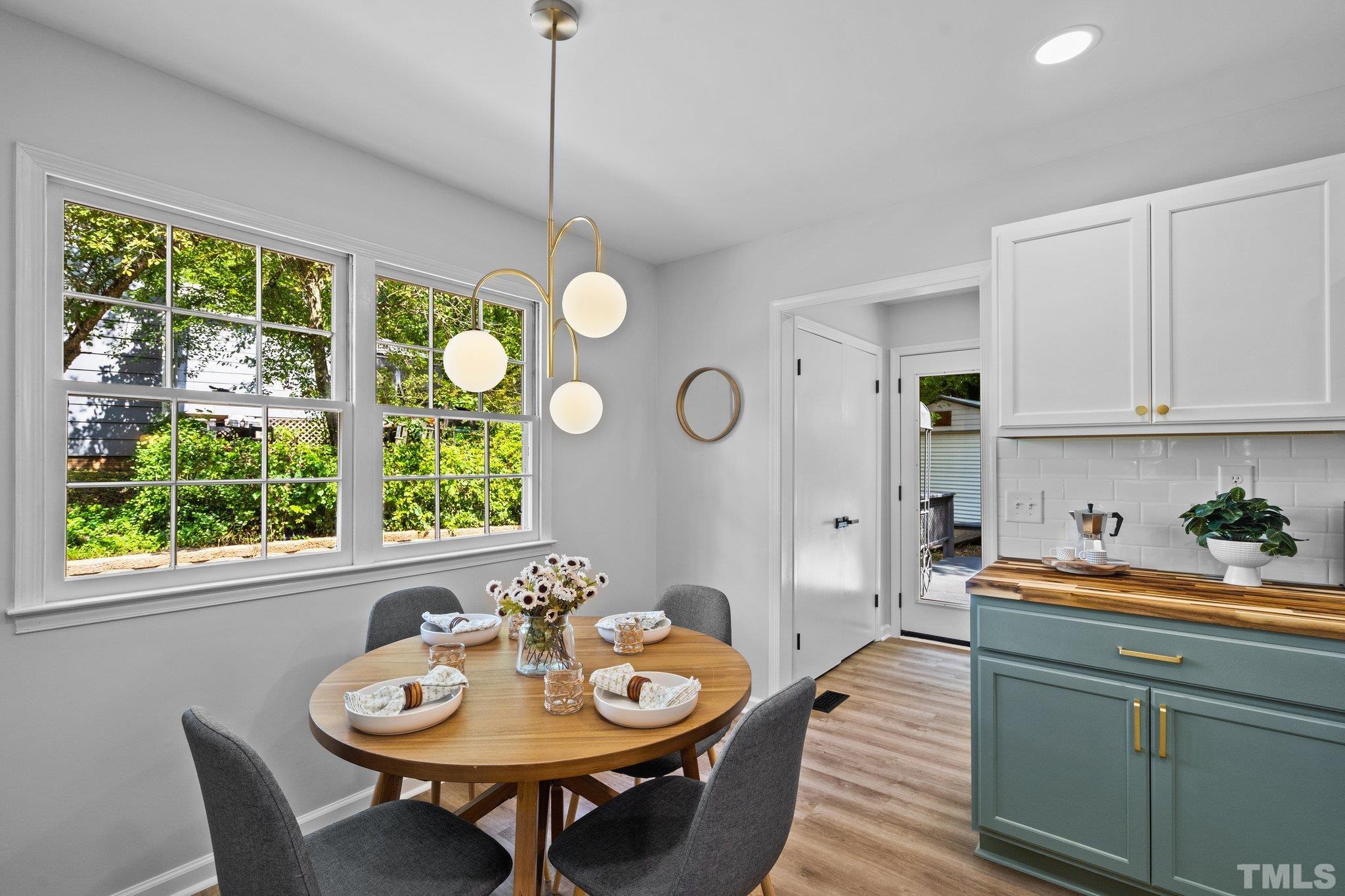 1013 Mockingbird Drive Raleigh, NC 27615 - Photo 14 of 41 a dining room with furniture a window and a chandelier