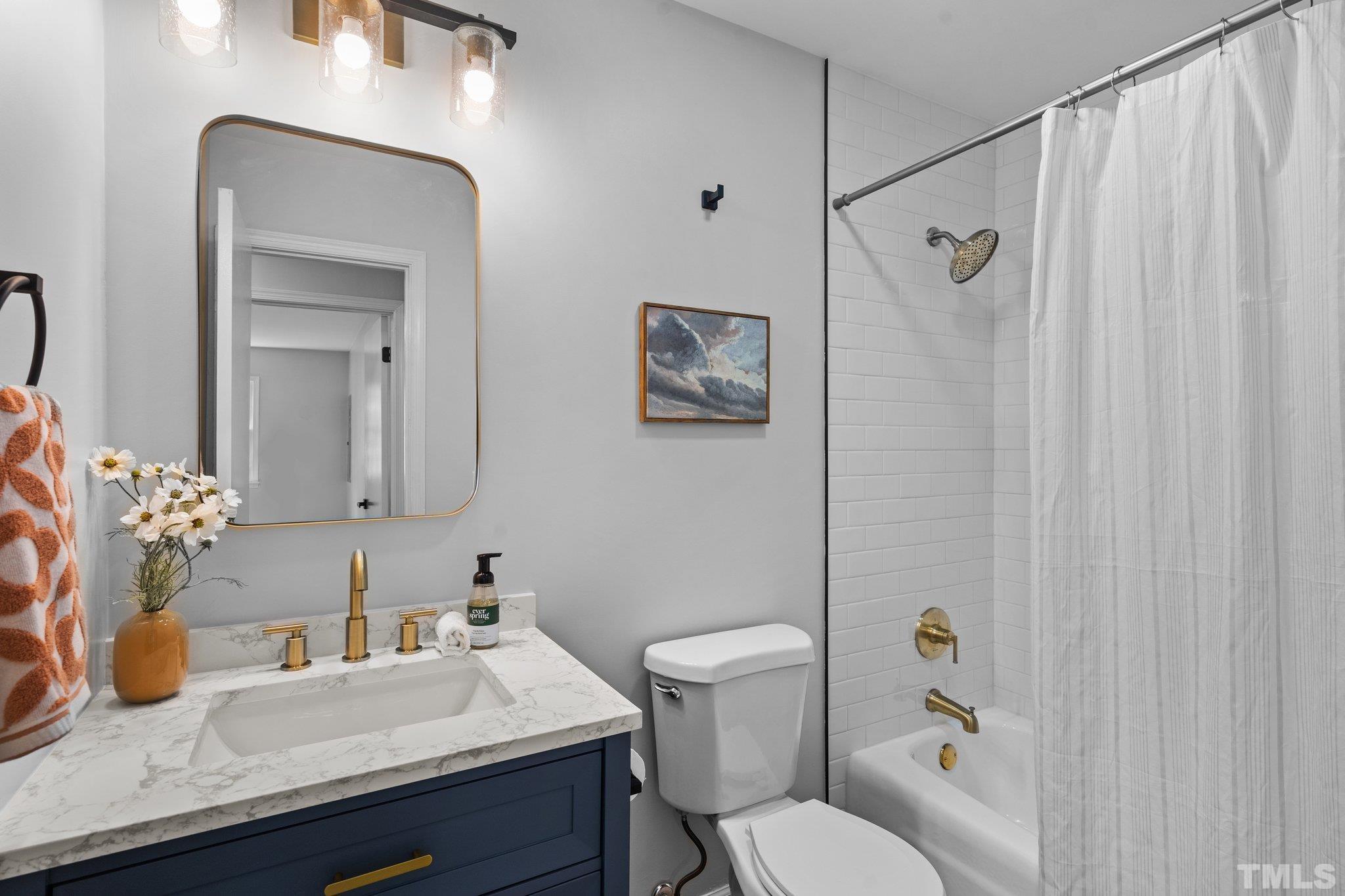 1013 Mockingbird Drive Raleigh, NC 27615 - Photo 21 of 41 a bathroom with a sink vanity mirror and toilet