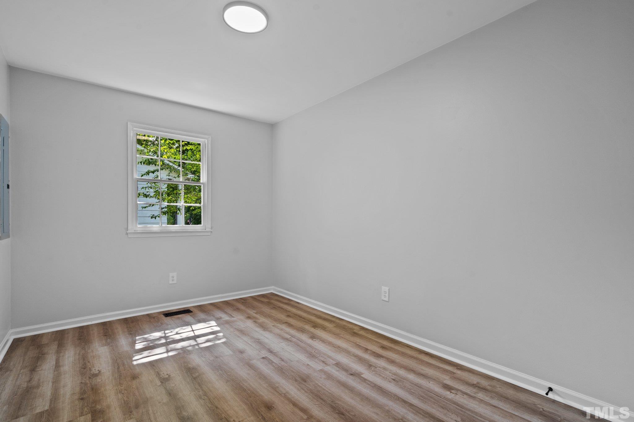 1013 Mockingbird Drive Raleigh, NC 27615 - Photo 22 of 41 wooden floor in an empty room with a window