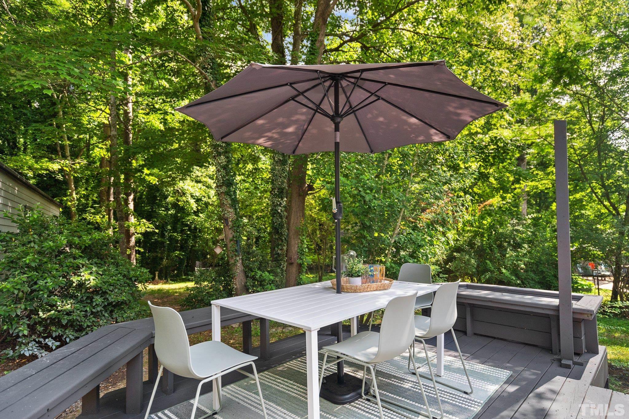 1013 Mockingbird Drive Raleigh, NC 27615 - Photo 32 of 41 a patio with wooden floor a yard a table and chairs
