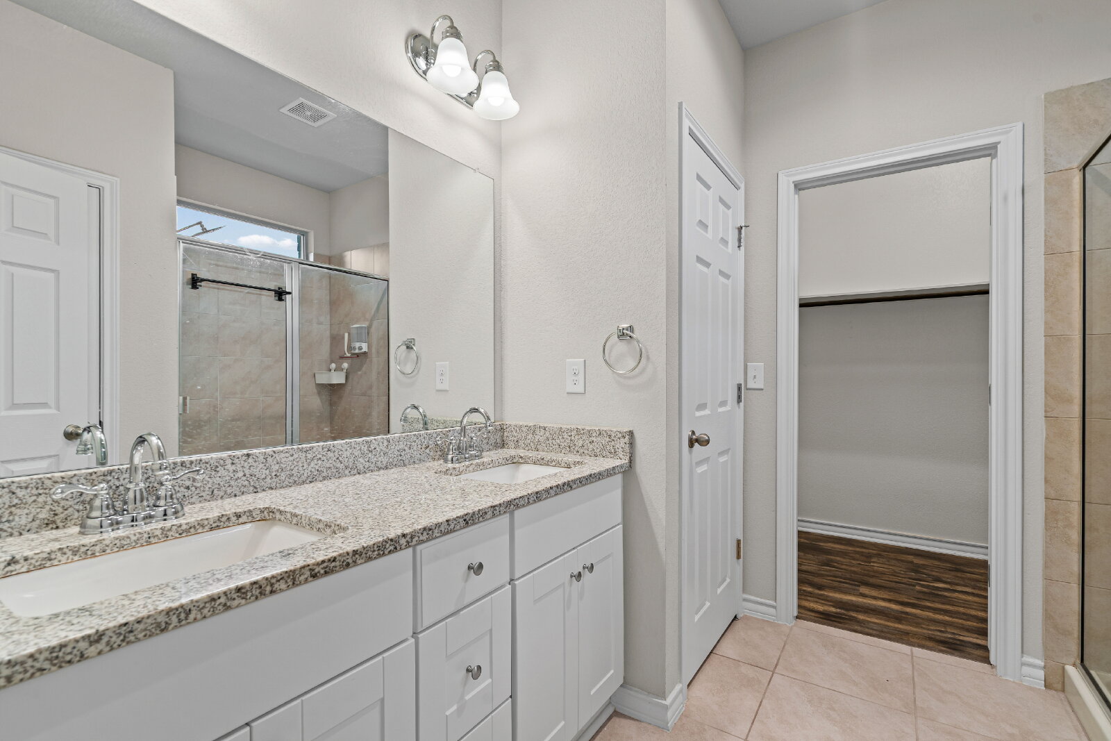 204 Tulum Terrace Leander, TX 78641 - Photo 14 of 22 Bathroom with double vanity, light tile patterned floors, a stall shower, and a walk in closet