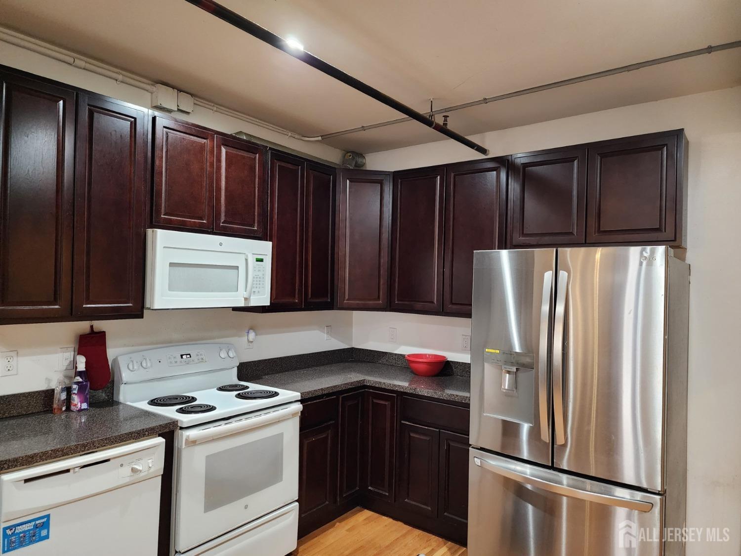 378 George Street, Unit 201 New Brunswick, NJ 08901 - Photo 2 of 10 a kitchen with a refrigerator sink and cabinets