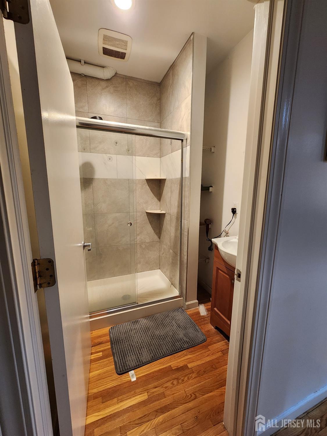 378 George Street, Unit 201 New Brunswick, NJ 08901 - Photo 4 of 10 a bathroom with a glass shower door