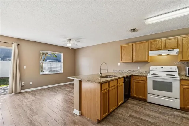 a kitchen with stainless steel appliances granite countertop a stove a sink and a microwave