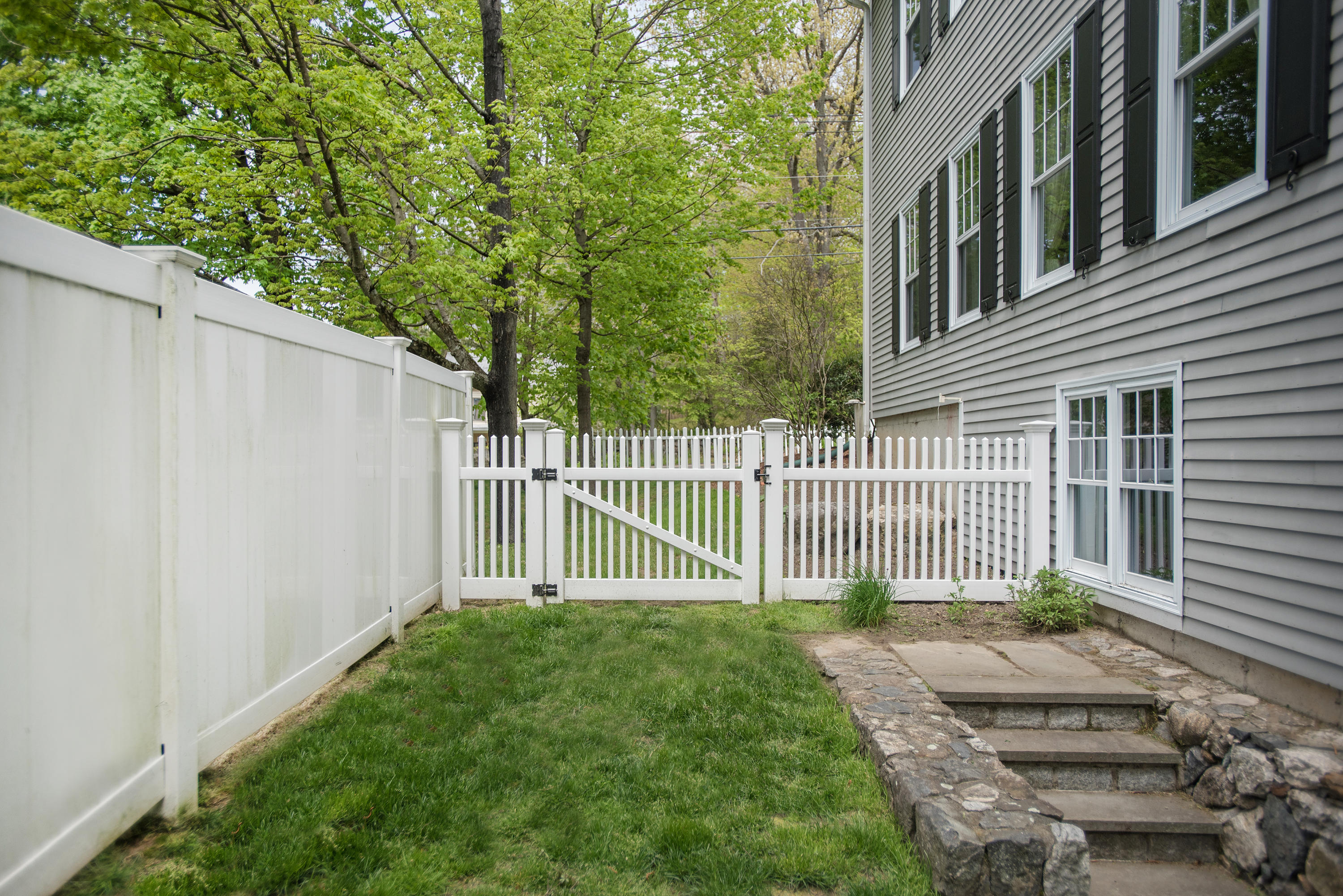 17 Brushy Ridge Road New Canaan, CT 06840 - Photo 33 of 35 a view of a house with a small yard and wooden fence
