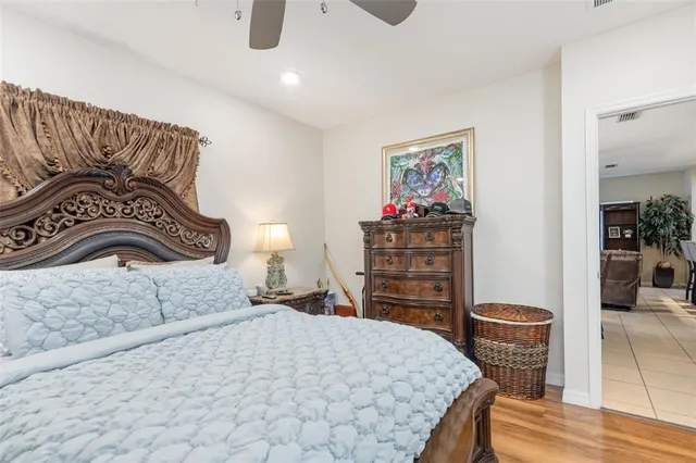 a bedroom with a bed a dresser and potted plants