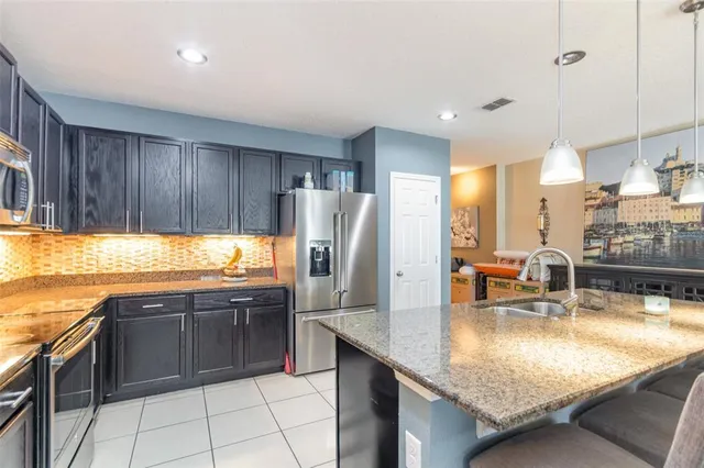 a kitchen with stainless steel appliances granite countertop a sink counter space and cabinets