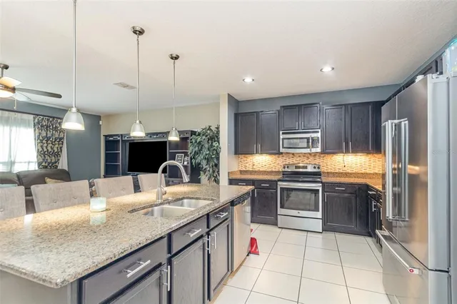 a kitchen with stainless steel appliances granite countertop a sink refrigerator and cabinets