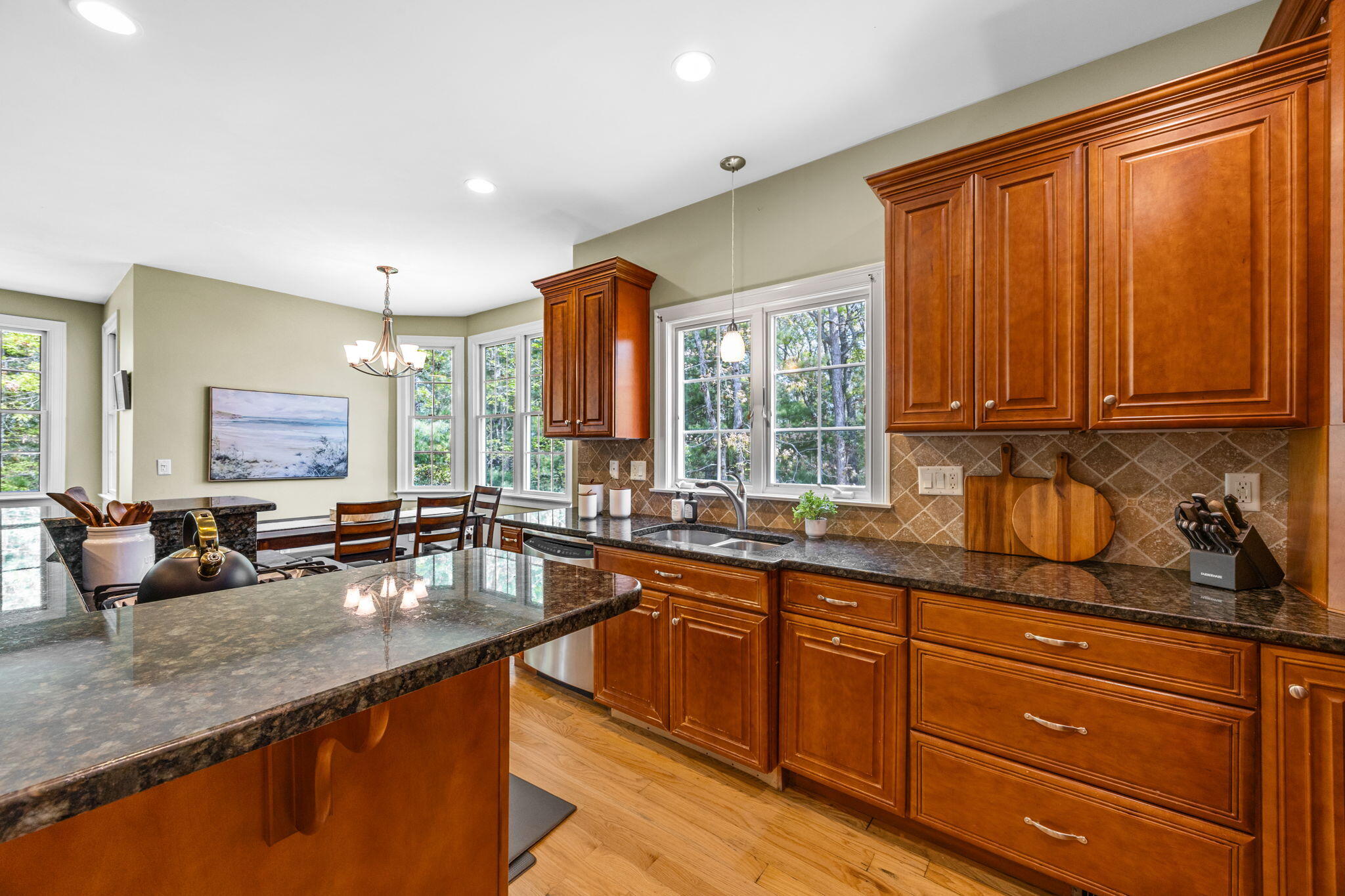 17 Payamps Road Mashpee, MA 02649 - Photo 35 of 72 a kitchen with granite countertop wooden cabinets a sink and dishwasher with wooden floor