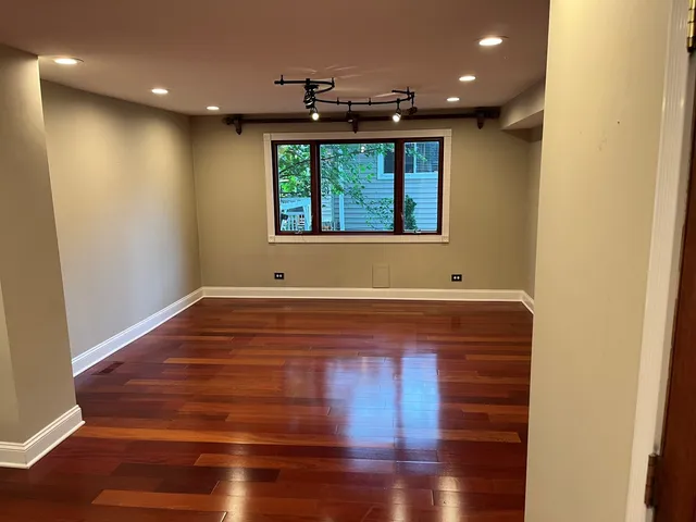 a dining room with stainless steel appliances kitchen island granite countertop a table chairs and a refrigerator