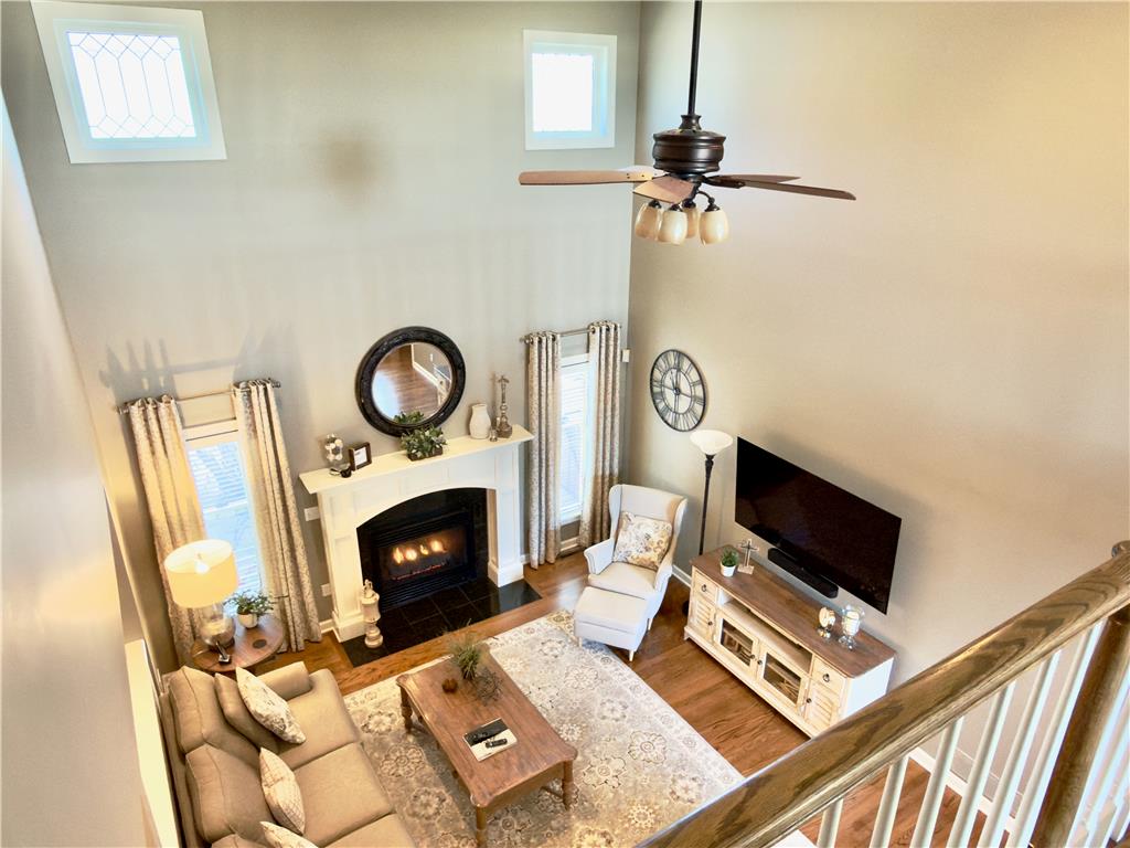 4982 Abbey Road Coplay, PA 18037 - Photo 10 of 55 A high-ceilinged living space centers around a classic fireplace surrounded by warm hardwood floors.