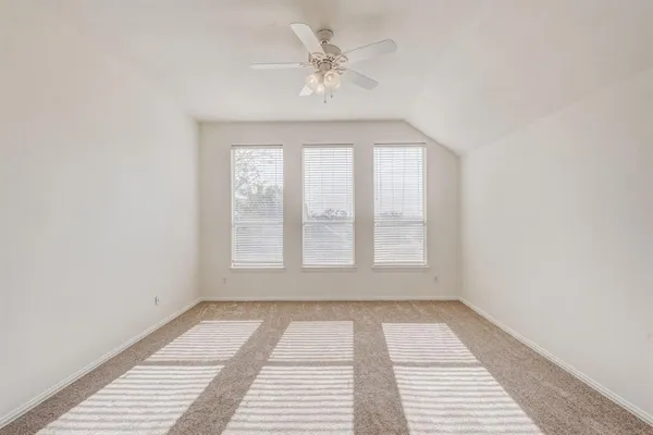 an empty room with windows and ceiling fan