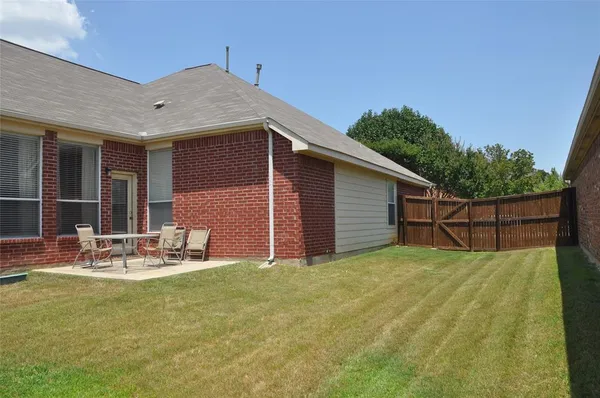 a view of a backyard with table and chairs and wooden fence