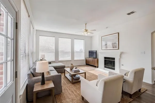 a living room with furniture fireplace and a large window