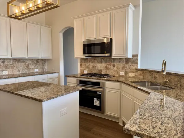 a kitchen with stainless steel appliances granite countertop a sink stove and microwave