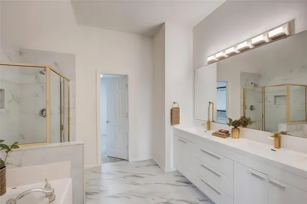 a bathroom with a double vanity sink mirror and shower