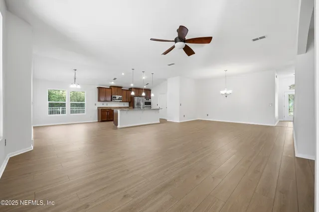 a view of a livingroom with a hardwood floor and a ceiling fan
